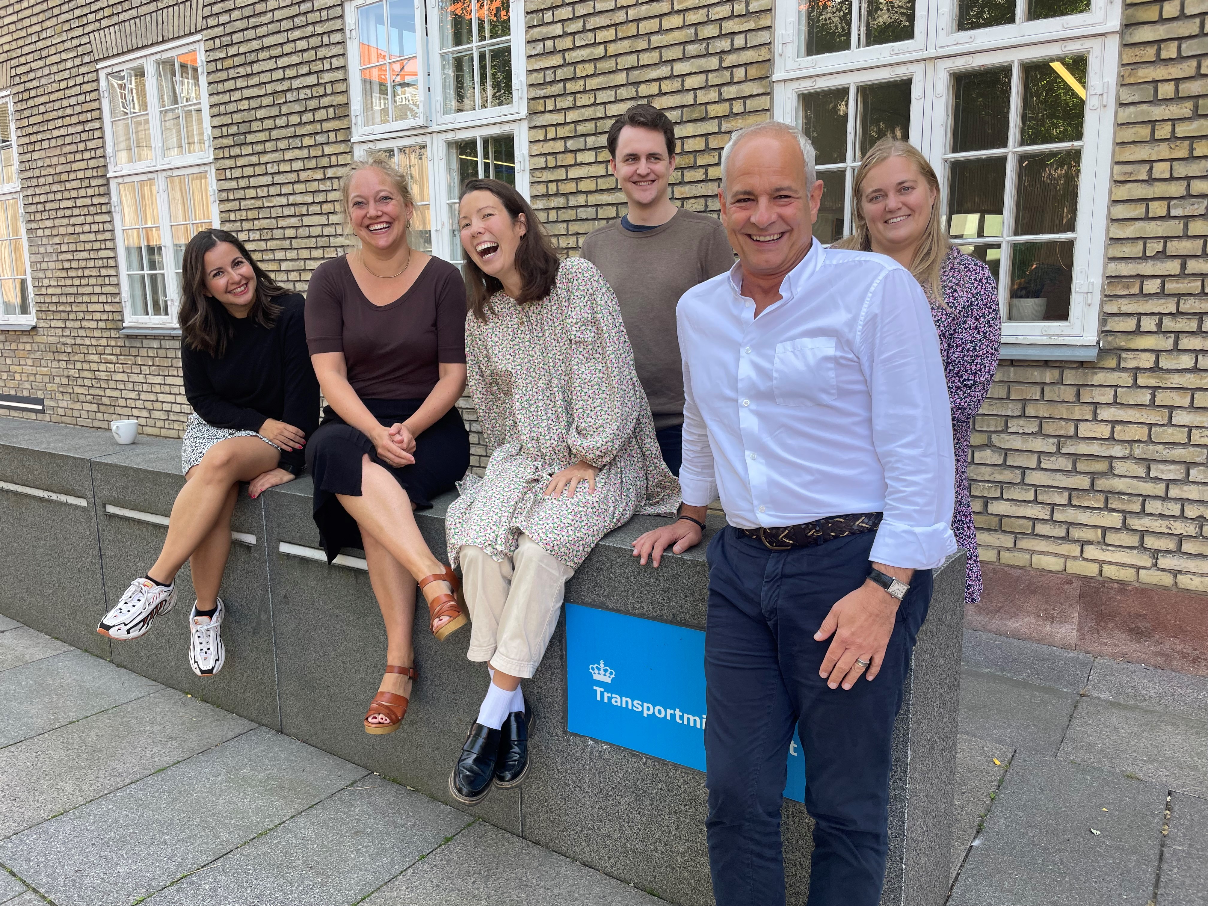 Medarbejdere og chefen for HR står samlet uden for ministeriets hovedindgang.